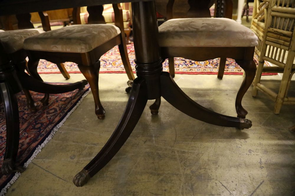 A reproduction mahogany twin pillar extending dining table and eight George I style chairs, 300cm extended (two spare leaves)